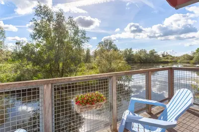 a deck with two chairs and a potted plant at Hajé Hotel Restaurant de Lepelaar in Lelystad