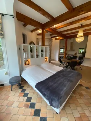 a large bedroom with a large bed and a table at Hajé Hotel Restaurant de Lepelaar in Lelystad