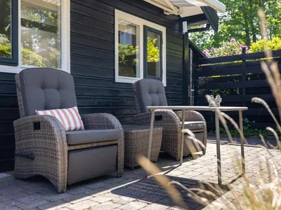 two chairs and a table on a patio at De Groeter Lodge in Groet