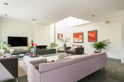 a living room with two couches and a tv at Villa Red Cedar in Bergen