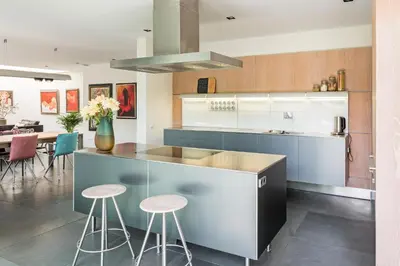 a kitchen with a counter and stools in it at Villa Red Cedar in Bergen