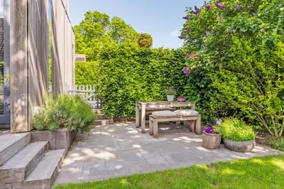 a patio with a table and some plants at Villa Red Cedar in Bergen