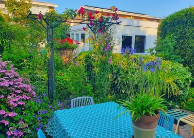 a table and chairs in a garden with flowers at B&B Evergreen in Wijdewormer