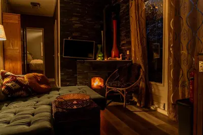 a living room with a couch and a fireplace at Wellness oase Egmond in Egmond aan den Hoef