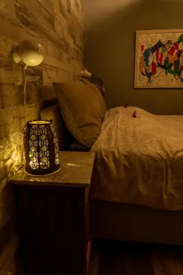 a bedroom with a bed and a table with a lamp at Wellness oase Egmond in Egmond aan den Hoef