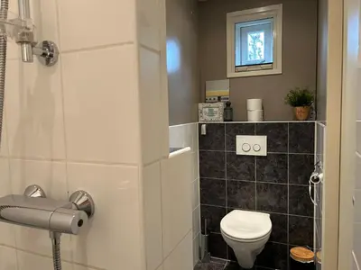 a small bathroom with a toilet and a window at Warmhuisje in Warmenhuizen