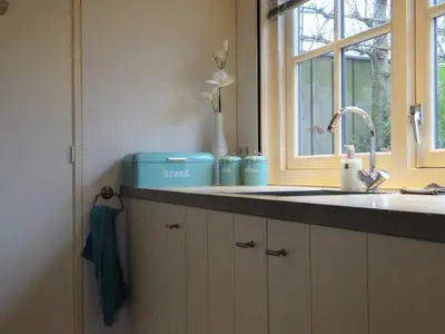 a kitchen counter with a sink and a window at Warmhuisje in Warmenhuizen