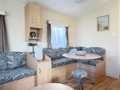 a living room with a couch and a table at Chalet 588 op Recreatiepark De Wielen in Sint Maarten