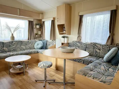 a living room with a couch and a table at Chalet 588 op Recreatiepark De Wielen in Sint Maarten