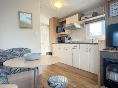 a kitchen and a table in a small room at Chalet 588 op Recreatiepark De Wielen in Sint Maarten