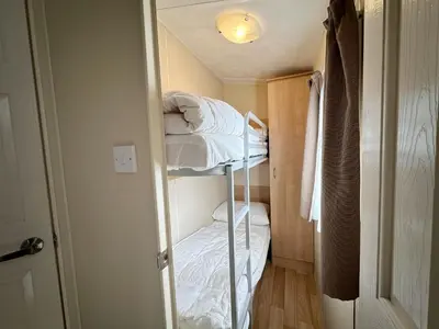 a small room with two bunk beds in it at Chalet 588 op Recreatiepark De Wielen in Sint Maarten
