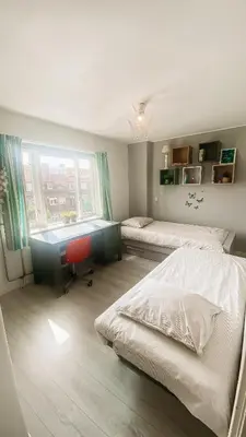 a bedroom with two beds and a desk and a window at Charming Entire Home Near Amsterdam in Hilversum