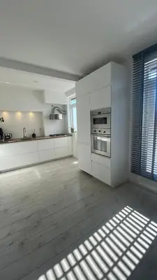 a large kitchen with white cabinets and a window at Charming Entire Home Near Amsterdam in Hilversum
