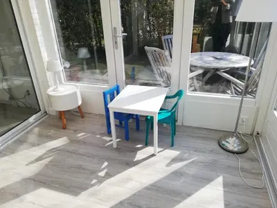 a porch with a table and chairs and a table at Zeemeeuw in Egmond aan den Hoef
