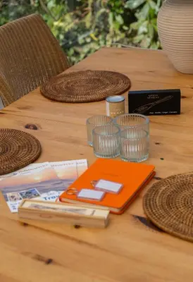 a table with an orange notebook on a wooden table at Zeemeeuw in Egmond aan den Hoef