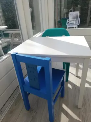 a white table with a blue chair sitting under it at Zeemeeuw in Egmond aan den Hoef