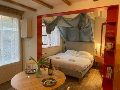 a bedroom with a bed and a table with a table sidx sidx sidx at charming studio in Amsterdam-Noord in Amsterdam