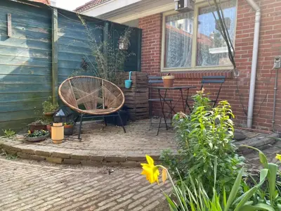 a patio with a chair and a table in a house at charming studio in Amsterdam-Noord in Amsterdam