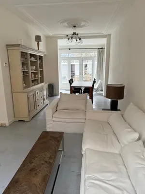 a living room with a white couch and a table at Casa Hofdijkstraat in Alkmaar