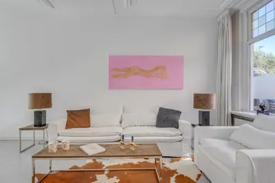 a living room with two white couches and a table at Casa Hofdijkstraat in Alkmaar