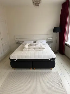 a bedroom with a bed with a white mattress at Casa Hofdijkstraat in Alkmaar