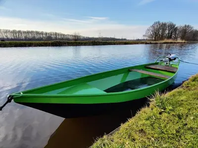 a green boat parked on the side of a lake at Park De Driesprong in Nieuwveen