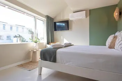a bedroom with a large bed and a window at Smile Studio's in Zandvoort