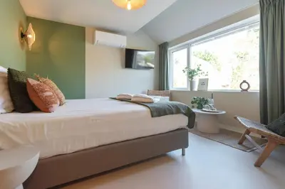 a bedroom with a large bed and a window at Smile Studio's in Zandvoort