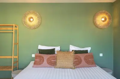 a bedroom with a bed with pillows and green walls at Smile Studio's in Zandvoort