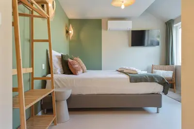 a bedroom with a bunk bed and a ladder at Smile Studio's in Zandvoort