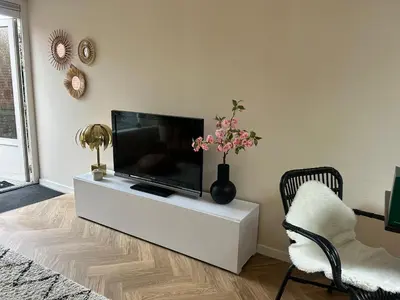 a living room with a flat screen tv on a white entertainment center at Beachhouse Wijk aan Zee! in Wijk aan Zee