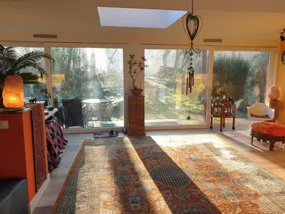 a living room with a large window and a rug at Heidy's Home, with Wellness Facilities in Zeewolde