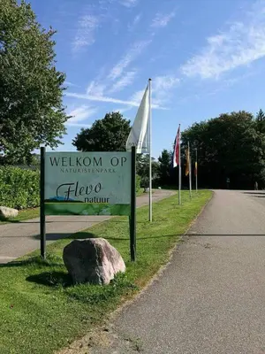 a sign on the side of a road with a rock at Heidy's Home, with Wellness Facilities in Zeewolde