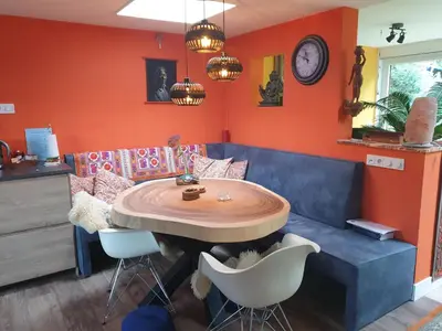 a dining room with a table and a couch at Heidy's Home, with Wellness Facilities in Zeewolde