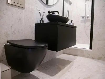 a bathroom with a black toilet and a sink at CANAL APARTMENT AMSTERDAM CENTRAL 4p in Amsterdam