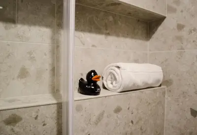 a towel and a rubber duck sitting on a shelf in a shower at CANAL APARTMENT AMSTERDAM CENTRAL 4p in Amsterdam