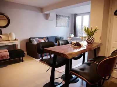 a living room with a wooden table and leather chairs at CANAL APARTMENT AMSTERDAM CENTRAL 4p in Amsterdam