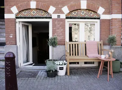 a wooden bench sitting in front of a building at CANAL APARTMENT AMSTERDAM CENTRAL 4p in Amsterdam