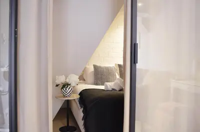 a room with a bed and a table with a vase of flowers at CANAL APARTMENT AMSTERDAM CENTRAL 4p in Amsterdam