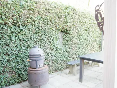 a fire hydrant next to a bench next to a hedge at Karibu in Tuitjenhorn