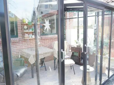 a patio with a table and chairs and a brick wall at Karibu in Tuitjenhorn