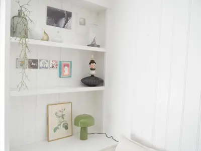 a living room with white walls and white shelves at Karibu in Tuitjenhorn