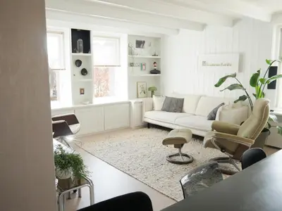 a living room with a white couch and chairs at Karibu in Tuitjenhorn