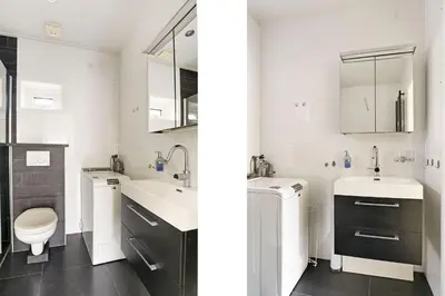 a white bathroom with two sinks and a toilet at 4 person Bungalow at beach, sea, dunes, lake, forestside in Noordwijkerhout