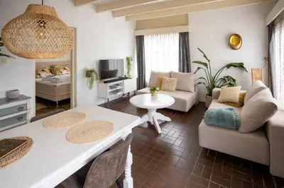 a living room with a couch and a table at 4 person Bungalow at beach, sea, dunes, lake, forestside in Noordwijkerhout