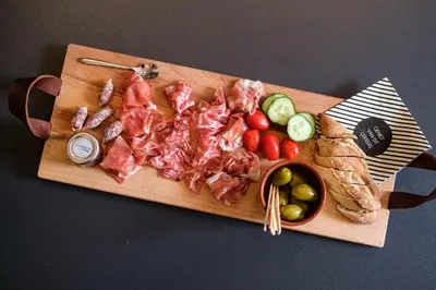 a cutting board with meat and vegetables and bread at Bed & Wellness De Leilinde in Nieuwe-Niedorp