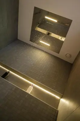 a bathroom with a mirror and a tiled floor at Bed & Wellness De Leilinde in Nieuwe-Niedorp