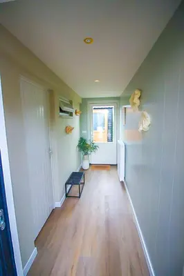 a room with a hallway with a refrigerator and a window at Het Vogelhuisje in Egmond aan den Hoef