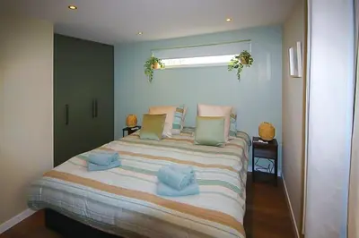 a bedroom with a large bed with blue pillows at Het Vogelhuisje in Egmond aan den Hoef