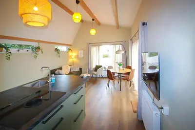 a kitchen and living room with a table and chairs at Het Vogelhuisje in Egmond aan den Hoef